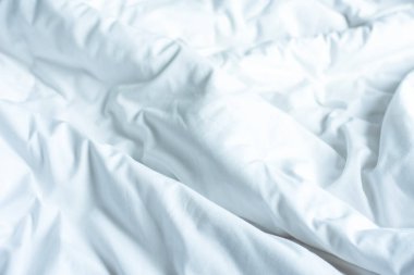 Yatak odasındaki kırışık, dağınık battaniye. Sabah uyandıktan sonra uzun bir gece yorganı ve battaniyesiyle beyaz battaniyeyi örtmekten..