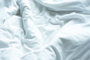 Beyaz çarşaflar, buruşuk yorganlar, buruşuk saten battaniyeler. Yorganlar otellerde, otellerde ya da evde iyi bir uykudan sonra kırışık yatak için kullanılır..