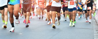 Sabah vakti maraton koşusu, yolda koşan insanlar, bacaklarda detay, adım, yürüyüş ve dışarıda egzersiz aktiviteleri kavramı..
