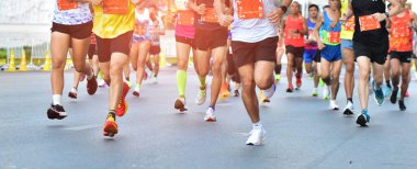 Sabah vakti maraton koşusu, yolda koşan insanlar, bacaklarda detay, adım, yürüyüş ve dışarıda egzersiz aktiviteleri kavramı..