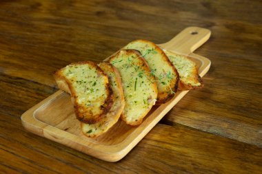 Tahta tabakta sarımsaklı ekmek, aşçılık konsepti..