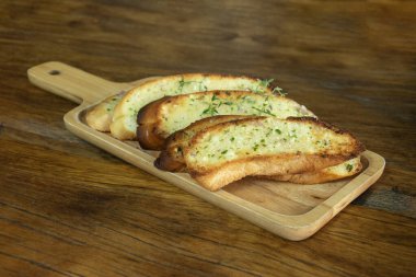 Tahta tabakta sarımsaklı ekmek, aşçılık konsepti..