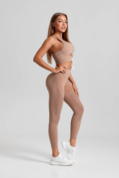 Fitness woman. Beautiful athletic girl, isolated on the gray background