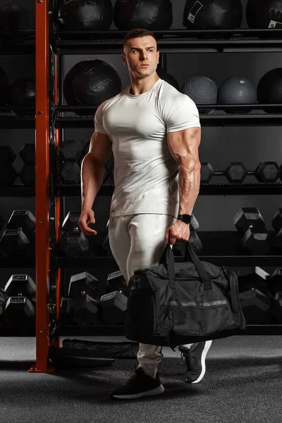 ジムでスポーツバッグを持つ筋肉の男 アスレチック男性はスポーツウェアを着用 — ストック写真