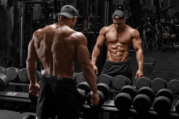 健身房的肌肉男在镜子里表现出肌肉 强壮的男性赤身裸体 — 图库照片