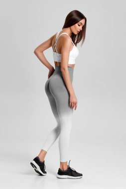 Gri arka plandaki atletik kız. Fitness kadını