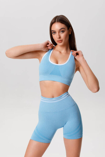 Fitness woman. Athletic girl on the gray background