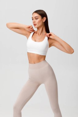 Fitness woman. Athletic girl on the gray background