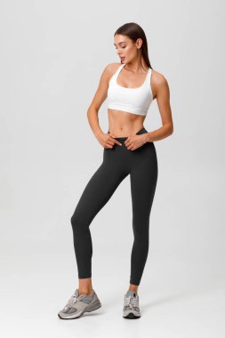 Fitness woman. Athletic girl on the gray background