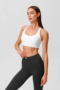 Fitness woman. Athletic girl on the gray background
