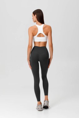 Fitness woman. Athletic girl on the gray background