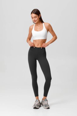 Fitness woman. Athletic girl on the gray background