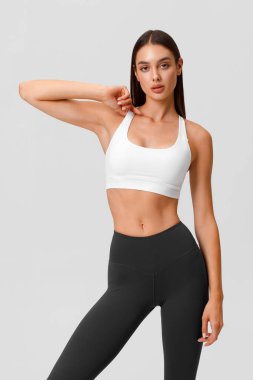 Fitness woman. Athletic girl on the gray background