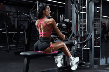 Jimnastik salonundaki kadın sırt egzersizi yapıyor. Kablo yayını yapan atletik kız