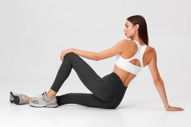 Fitness woman. Athletic girl on the gray background