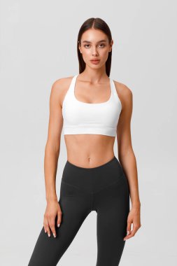 Fitness woman. Athletic girl on the gray background