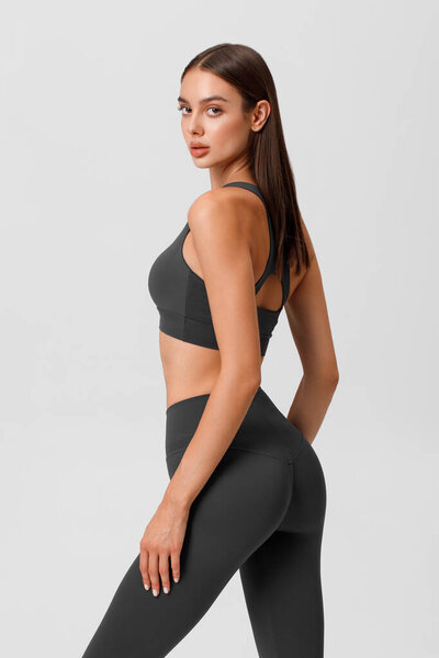 Fitness woman. Athletic girl on the gray background