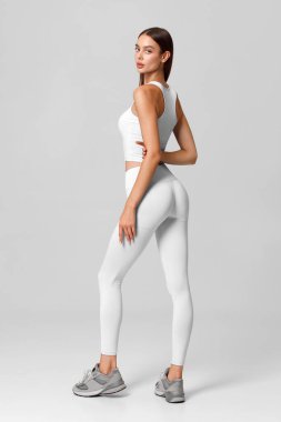 Gri arka plandaki atletik kız. Fitness kadını