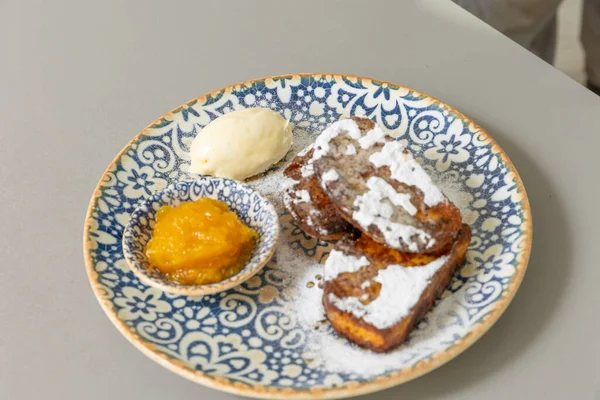 French toast served with peach jam and sugar