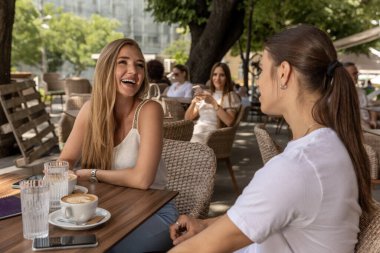 Dışarıdaki kafe barında arkadaşlar konuşuyor.