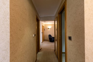 Kapısı olan bir otel koridorunun içi. 