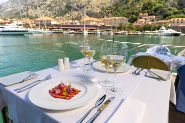 Restoran masasında şarap ile servis edilen tabakta balık fileto.