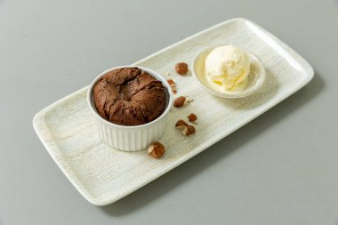 Vanilyalı dondurmayla servis edilen çikolatalı fındıklı kek.