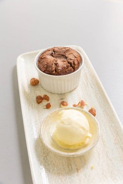 Vanilyalı dondurmayla servis edilen çikolatalı fındıklı kek.