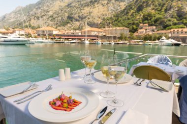 Restoran masasında şarap ile servis edilen tabakta balık fileto.