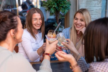 Kız arkadaşlar restoranda kadeh kaldırıyor.