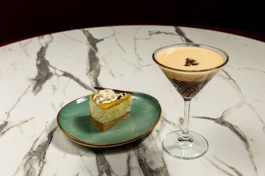 Coffee cocktail in a glass served with cake