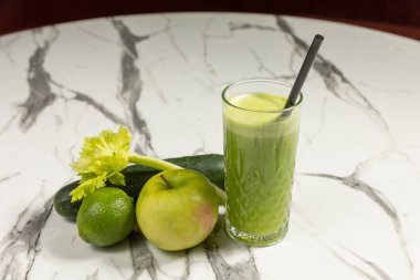 Apple cucumber lime celery juice in glass with ingredients
