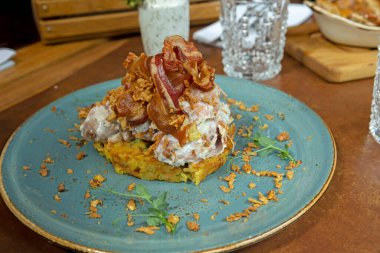 Smoked Ham hock with kajmak on rosti potatoes with crispy onions and bacon
