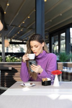 Harika bir kadın kafe barında kahve içiyor.