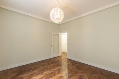 Interior of an empty apartment with brown wooden parquet
