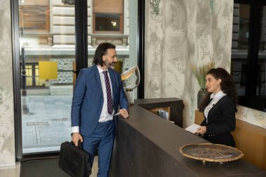Yakışıklı işadamı otel resepsiyonuna giriş yaptı.