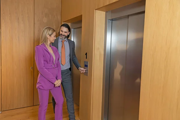 快乐的商业夫妻在等电梯 — 图库照片