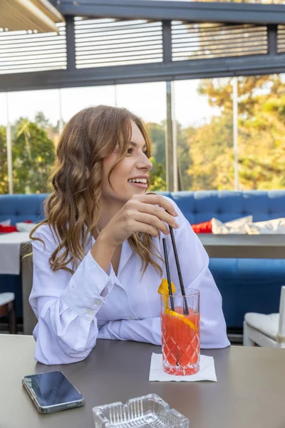 レストランで一人でカクテルを飲む若い女性 — ストック写真