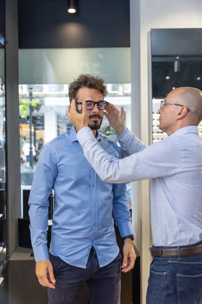 Homem Escolhendo Óculos Loja Óculos Com Uma Ajuda Óptico — Fotografia de Stock