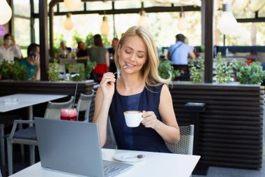 Kafe barında kahve içen muhteşem bir kadın.