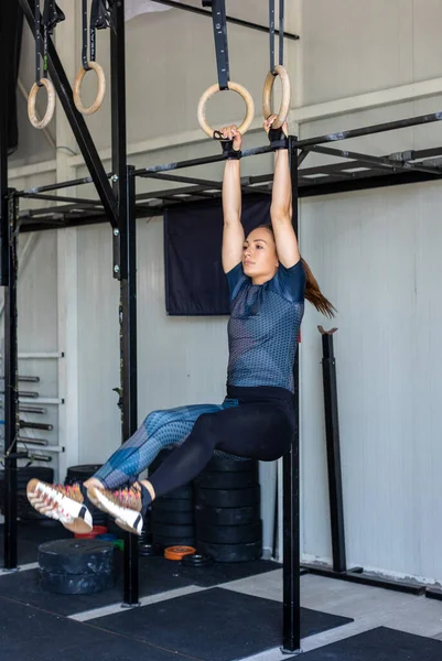 Fitness woman exercising on a gymnastic rings