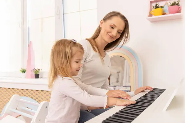 Niña Tocando Piano Con Madre Fotos De Stock