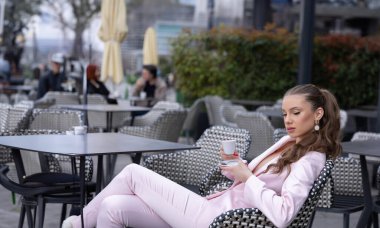 Lokantada yalnız başına kahve içen güzel bir moda kadını.