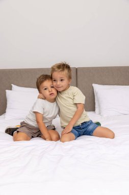 Yatak odasında oynayan kardeşler.