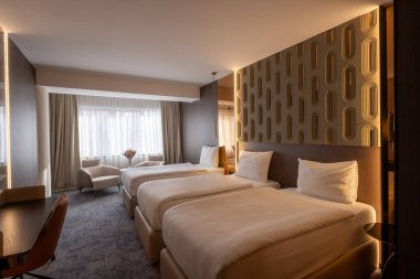 Ahşap duvar süslemesi olan lüks bir çift kişilik otel odası.