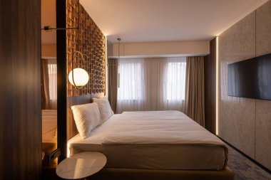 Ahşap duvar süslemesi olan lüks bir çift kişilik otel odası.