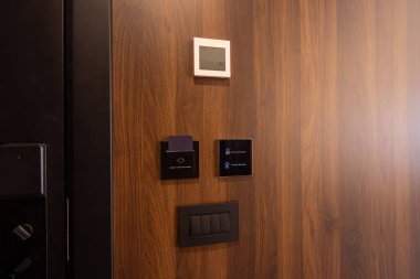Tahta otel odasının duvarında elektronik kapı ve klima kontrolü var.