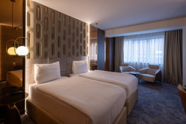 Ahşap duvar süslemesi olan lüks bir çift kişilik otel odası.