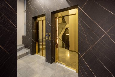 Asansör kapısı olan otel lobisi.