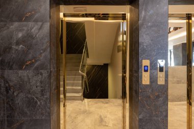 Asansör kapısı olan otel lobisi.